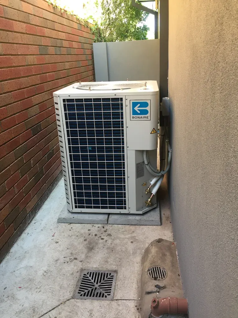 Bonaire ducted reverse-cycle outdoor unit installed on concrete pads