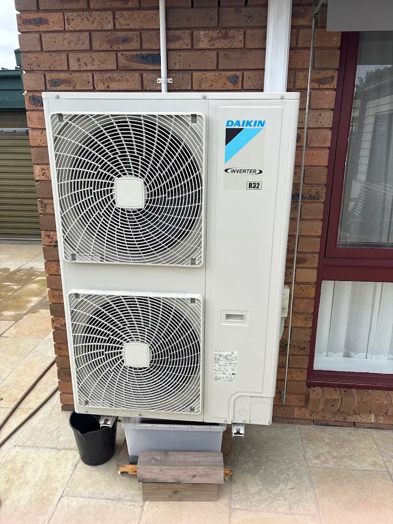 Daikin twin-fan multi-head condenser installed on a paved courtyard